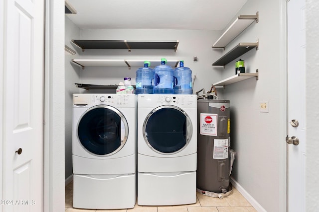 laundry area with water heater, washing machine and dryer, and light tile patterned flooring