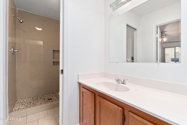 bathroom with vanity, a tile shower, and tile patterned floors