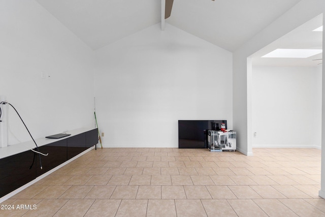 tiled spare room featuring vaulted ceiling with skylight