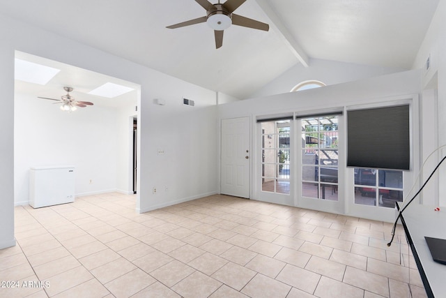 unfurnished living room with a skylight, beamed ceiling, ceiling fan, and light tile patterned flooring