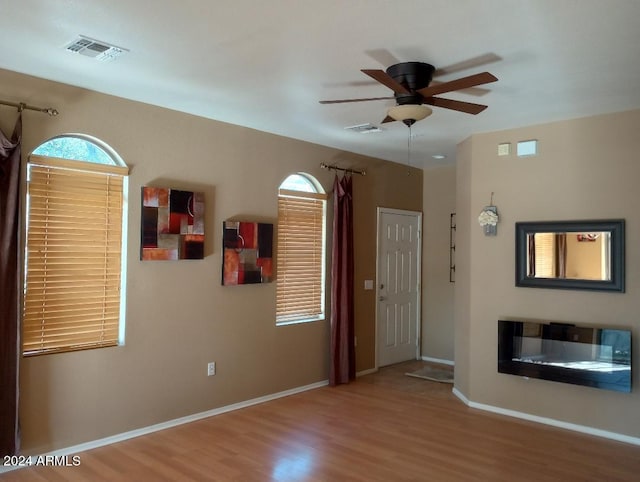 unfurnished living room featuring ceiling fan and hardwood / wood-style floors