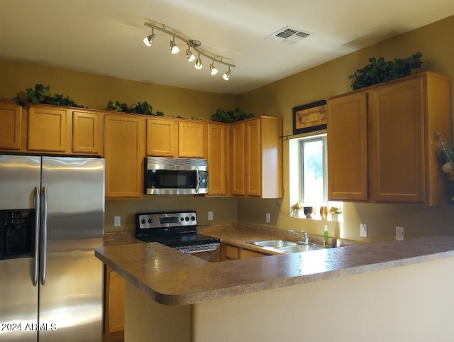 kitchen with kitchen peninsula, sink, and appliances with stainless steel finishes