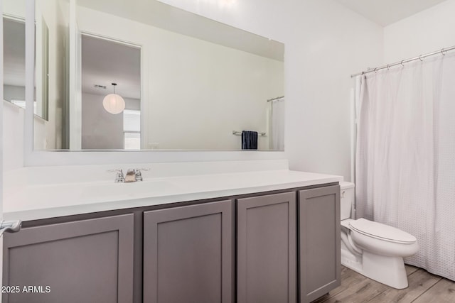 full bathroom with vanity, toilet, wood finished floors, and curtained shower