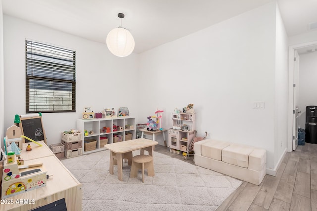 recreation room featuring light wood finished floors and baseboards
