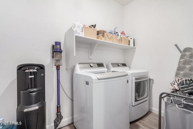 washroom with washer and clothes dryer, light wood-type flooring, and baseboards