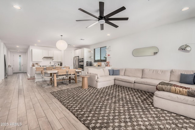 living area with a ceiling fan, light wood-style floors, and recessed lighting
