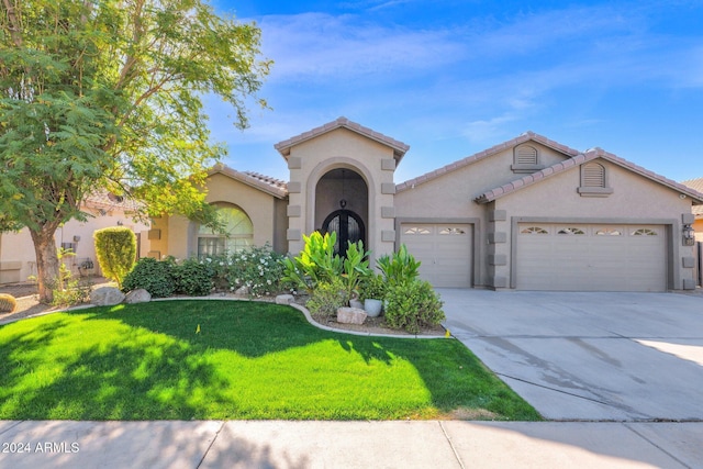 mediterranean / spanish-style house featuring a garage and a front yard