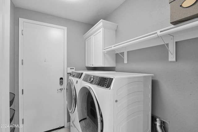 laundry room featuring washing machine and dryer and cabinets