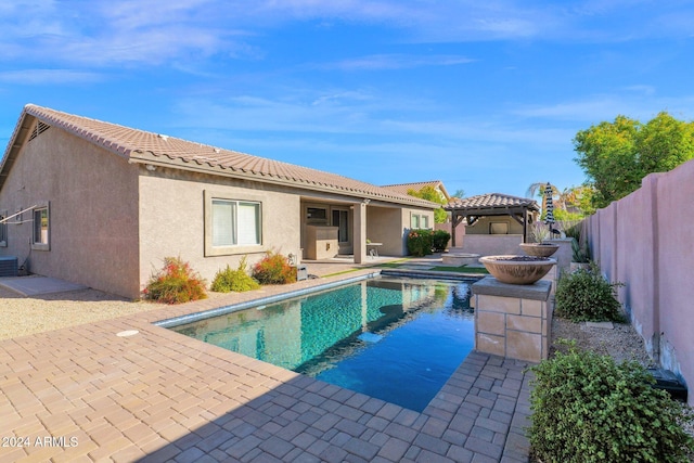 rear view of house featuring a gazebo, a fenced in pool, a patio area, and central air condition unit