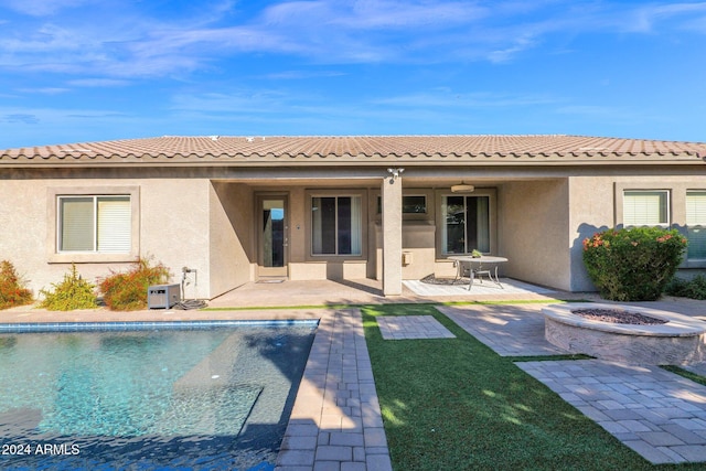 back of property featuring a patio and a fire pit