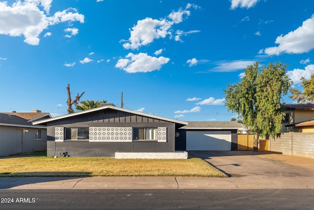 4518 W Rose Ln, Glendale, AZ 85301 - view of front of property featuring driveway, fence, an attached garage, board and batten siding, and a front yard