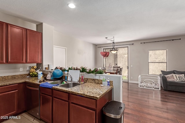 kitchen with light stone counters, kitchen peninsula, dishwasher, decorative light fixtures, and sink