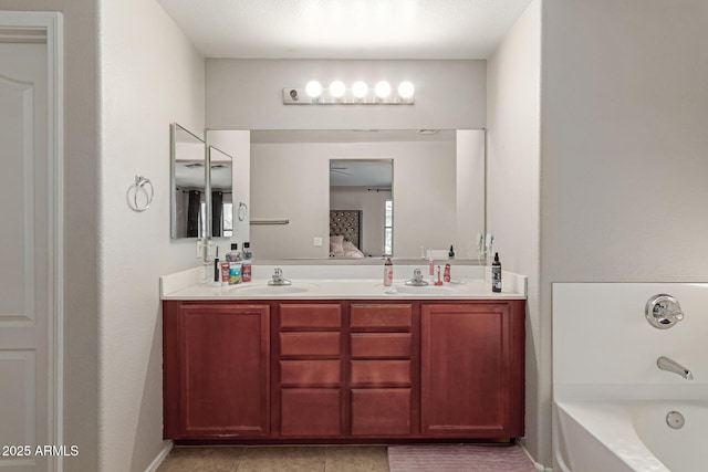 bathroom featuring vanity, tile patterned flooring, and a bathtub