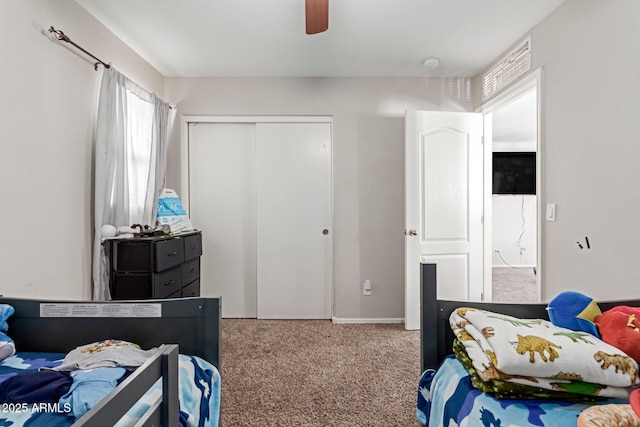 bedroom with light colored carpet, ceiling fan, and a closet