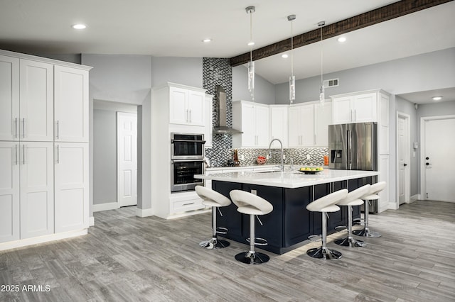 6102 E Nisbet Rd, Scottsdale, AZ 85254 - kitchen with lofted ceiling with beams, white cabinetry, a breakfast bar area, a kitchen island with sink, and stainless steel appliances