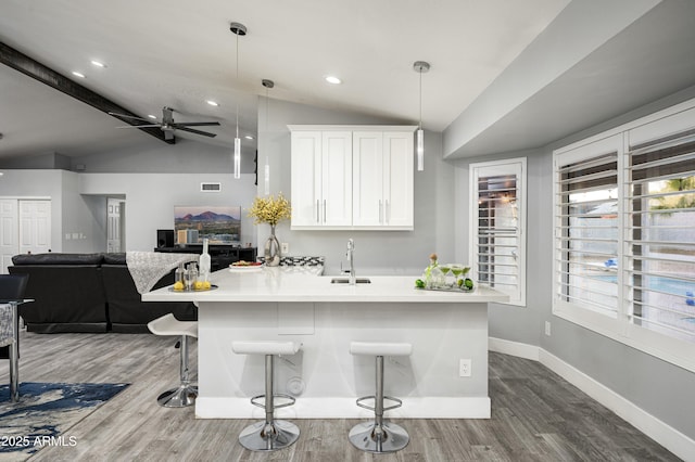 6102 E Nisbet Rd, Scottsdale, AZ 85254 - kitchen with sink, a kitchen breakfast bar, white cabinets, decorative light fixtures, and vaulted ceiling