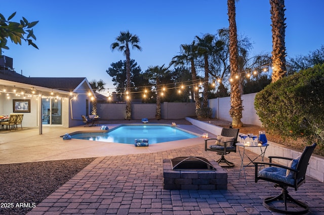 pool at dusk featuring a fire pit and a patio area