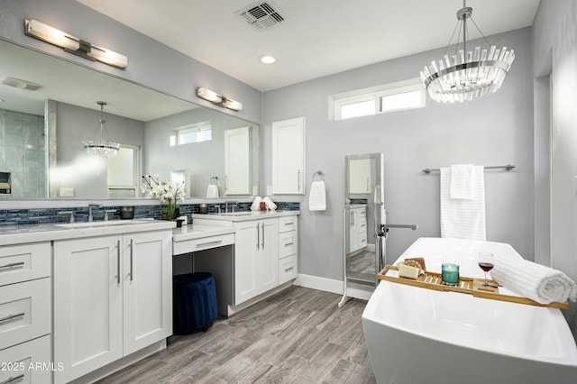 6102 E Nisbet Rd, Scottsdale, AZ 85254 - bathroom with a bathing tub, hardwood / wood-style floors, decorative backsplash, vanity, and a notable chandelier