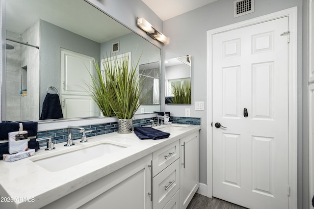 6102 E Nisbet Rd, Scottsdale, AZ 85254 - bathroom with vanity, backsplash, wood-type flooring, and a shower