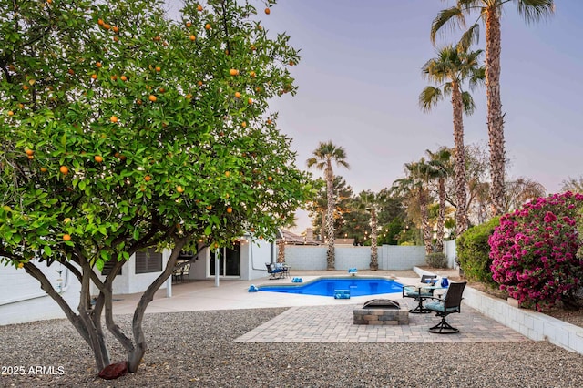 6102 E Nisbet Rd, Scottsdale, AZ 85254 - pool at dusk featuring a patio area and a fire pit