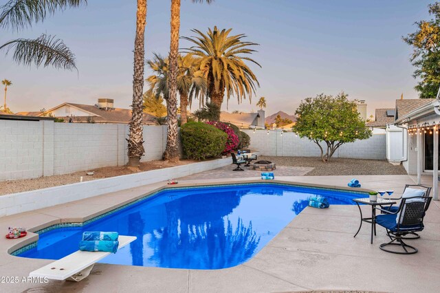 6102 E Nisbet Rd, Scottsdale, AZ 85254 - pool at dusk featuring a patio area and a fire pit