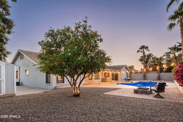 6102 E Nisbet Rd, Scottsdale, AZ 85254 - pool at dusk featuring a storage shed and a patio area