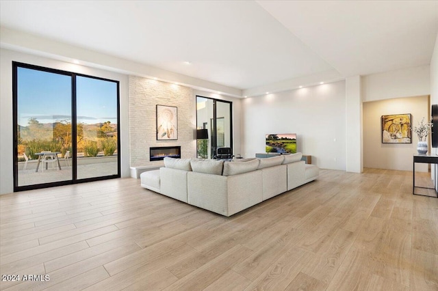 living room featuring a stone fireplace and light wood-type flooring