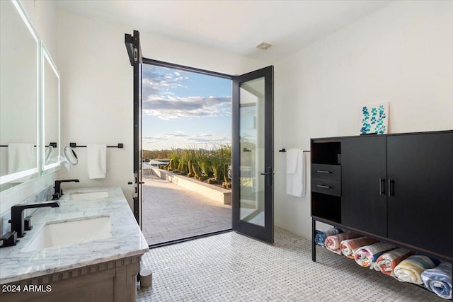 doorway to outside featuring sink and light tile patterned flooring