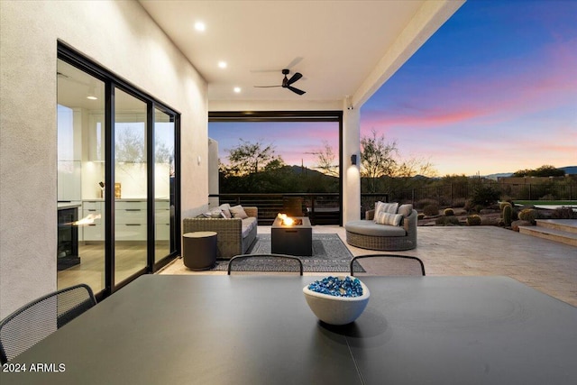 patio terrace at dusk featuring ceiling fan and outdoor lounge area