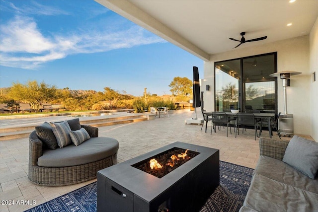 view of patio / terrace with a fire pit and ceiling fan