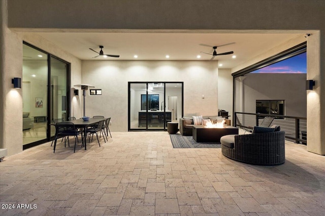 patio terrace at dusk featuring outdoor lounge area and ceiling fan