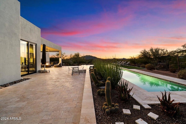 pool at dusk with a patio