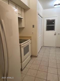kitchen featuring light tile patterned floors, under cabinet range hood, and white appliances