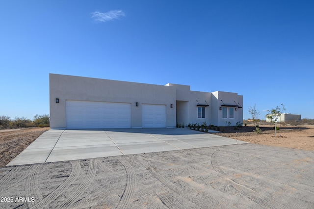 pueblo revival-style home featuring a garage