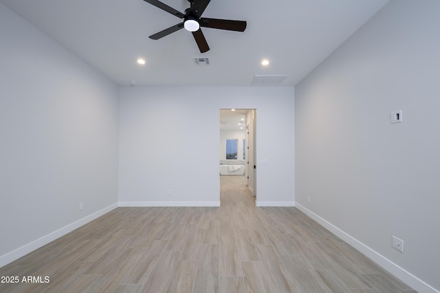 spare room with ceiling fan and light wood-type flooring