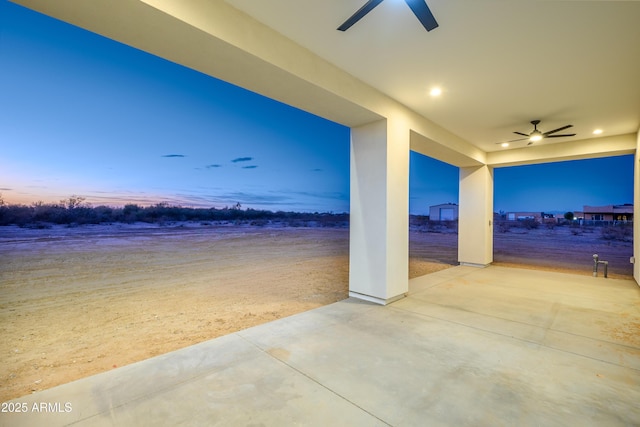 patio terrace at dusk featuring ceiling fan