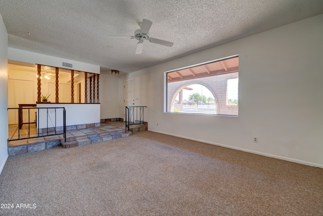 unfurnished room featuring a textured ceiling, carpet floors, and ceiling fan