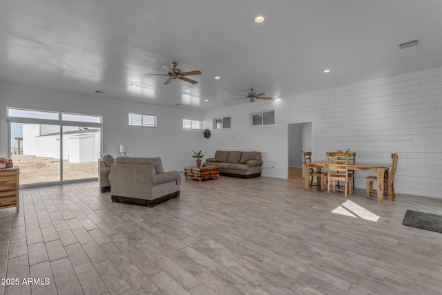 living room featuring ceiling fan and light hardwood / wood-style flooring