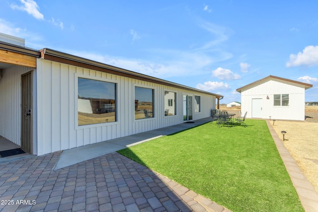 exterior space with a patio, a yard, and an outdoor structure