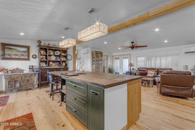 kitchen featuring light hardwood / wood-style flooring, pendant lighting, a center island, butcher block counters, and ceiling fan