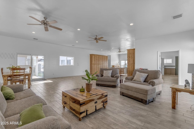 living room featuring ceiling fan and light hardwood / wood-style flooring