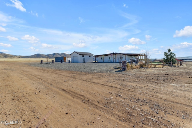 view of yard with a rural view and a mountain view