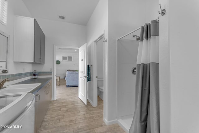 bathroom featuring sink, toilet, and curtained shower