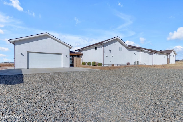 view of front of property with a garage and central AC