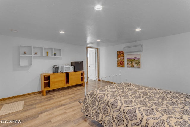 bedroom featuring hardwood / wood-style flooring and a wall unit AC