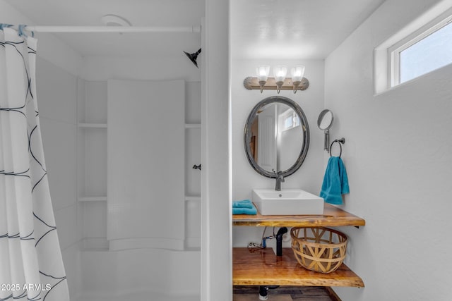 bathroom featuring curtained shower and sink