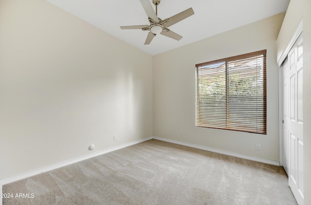 unfurnished bedroom featuring ceiling fan, light carpet, and vaulted ceiling