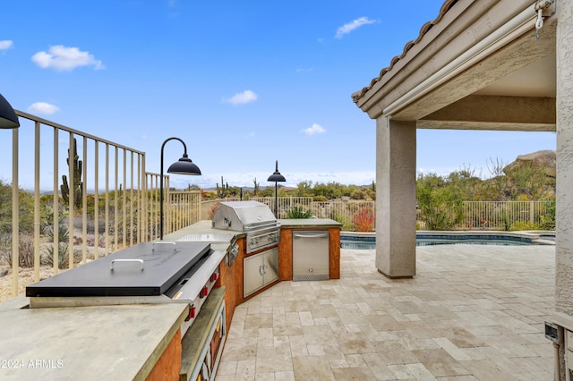 view of patio featuring an outdoor kitchen, a fenced in pool, and a grill