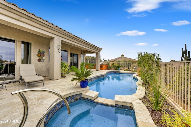 view of swimming pool with pool water feature, an in ground hot tub, and a patio