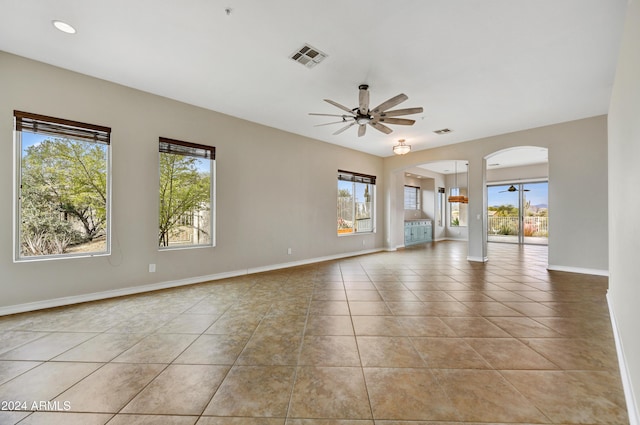 tiled spare room featuring ceiling fan